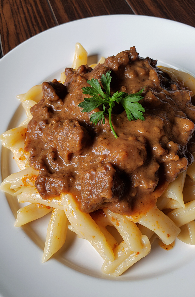 Cajun Steak with Parmesan Rigatoni | Amateur Close-Up from Reddit, Shot on iPhone 17 Pro Daytime Side Angle, Shot by Amateur, Mouthwatering and delicious homemade Cajun steak in creamy Parmesan rigatoni, featuring tender cuts of meat topped with a rich, velvety cheese sauce, served with slow-cooked rigatoni pasta and garnished with fresh parsley. --iw 3